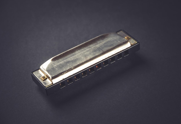 Vintage mondharmonica geïsoleerd op zwart