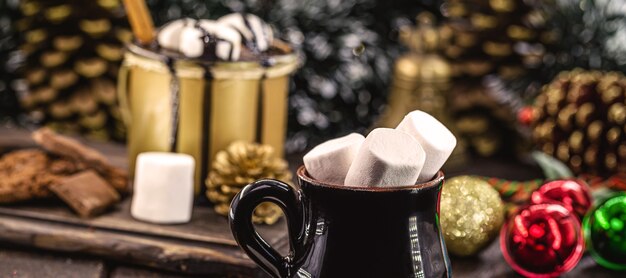 Vintage mug with lots of marshmallows inside, decorated Christmas setting, typical sweet drinks and New Year's dessert