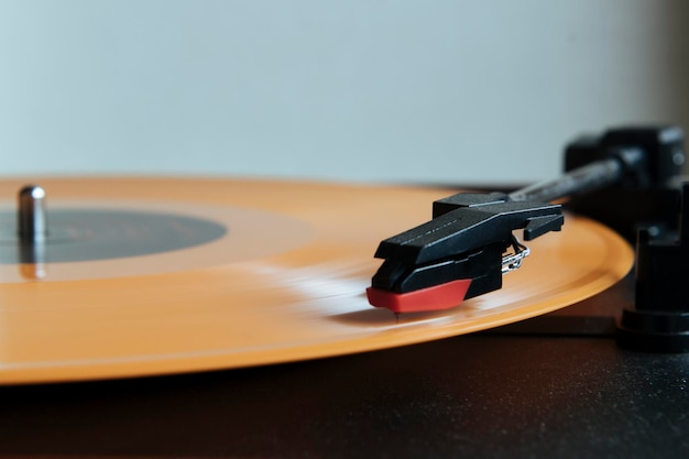 Vintage needle turntable with orange record playing