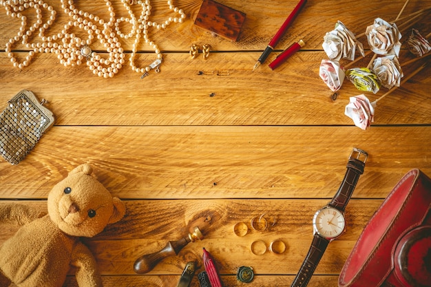 Oggetti vintage e gioielli in un tavolo di legno con copia spazio nel mezzo.