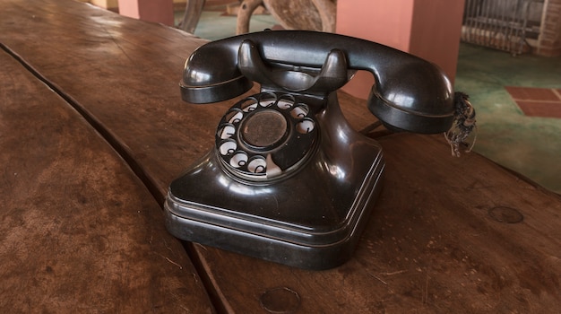 Foto vintage - vecchio telefono nero retrò su un tavolo di legno