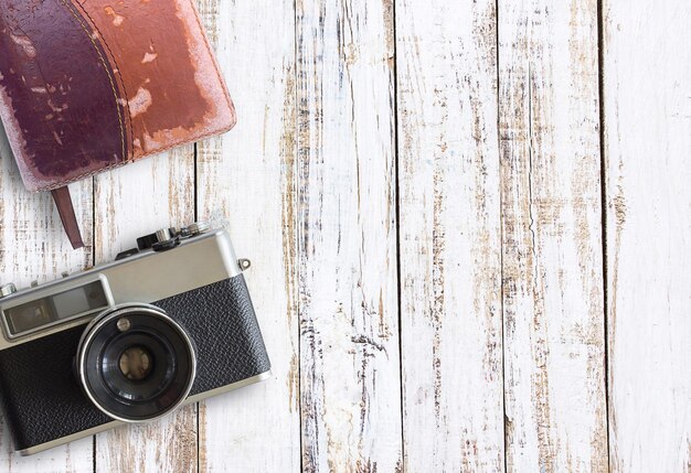 Vintage old camera and notebook on white wooden table background