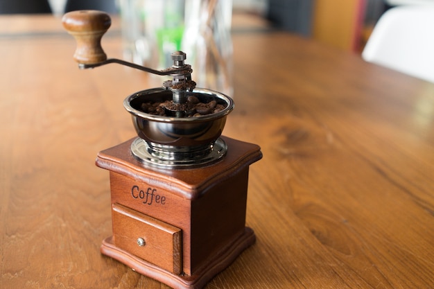 Vintage old Coffee grinder on wood table with sun light