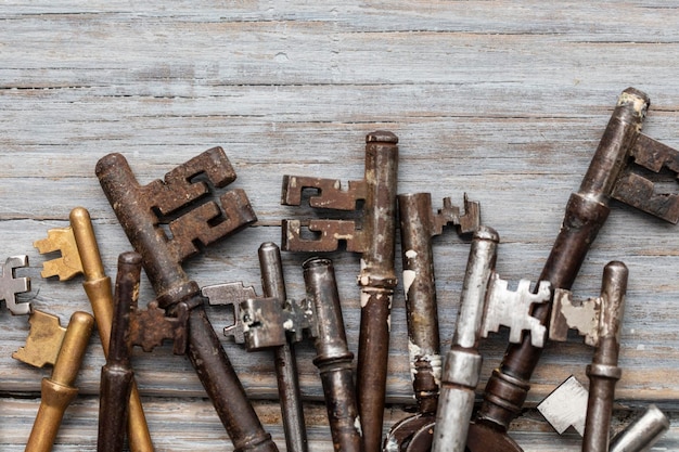 Vintage old fashioned keys on a rustic wooden background Security concept