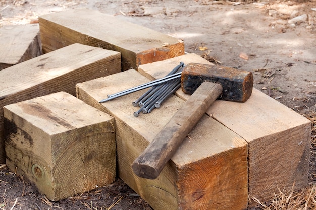 Vintage old rusty hammer and nails lying on wooden bars