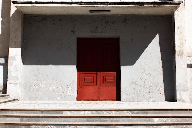 Vintage vecchia porta in legno di edificio in cemento con pareti bianche gradini in marmo ombre nitide