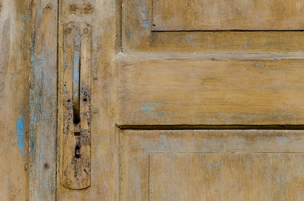 Vintage old wooden door and rusty iron knocker closeup