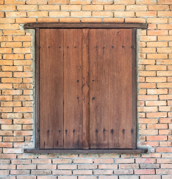 Винтажное старое деревянное окно на фоне кирпичной стены