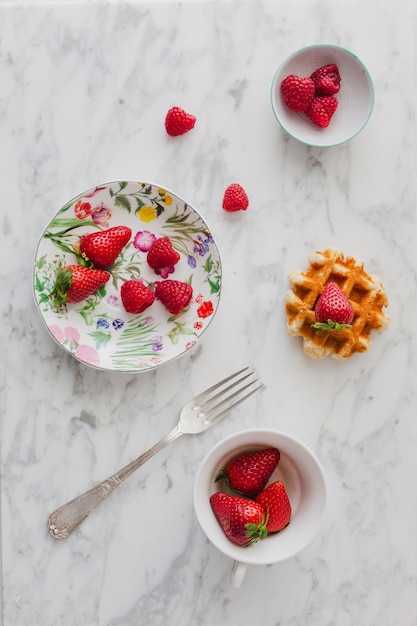 Vintage ontbijt met wafels en rode bessen op witte achtergrond