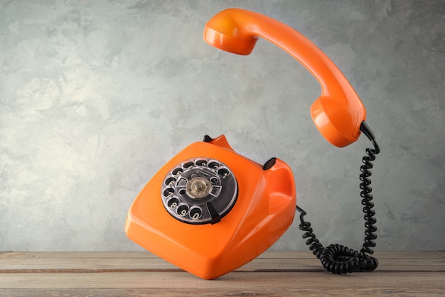 Vintage orange phone levitate over the table