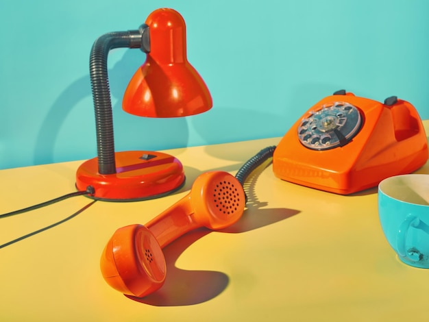 Foto vintage oranje telefoon tafellamp en koffiekopje