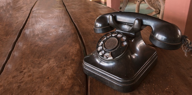 Vintage - Oude zwarte telefoon retro op een houten tafel