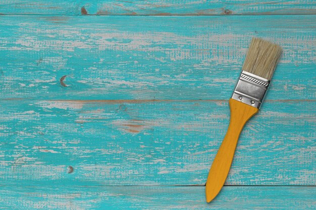 Vintage Paintbrush on Turquoise Wooden Surface for Artistic and DIY Projects