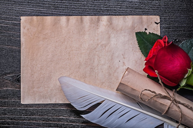 木の板にヴィンテージ紙ロール赤いバラの羽