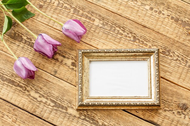 vintage photo frame with lilac tulips and copy space on old wooden boards.