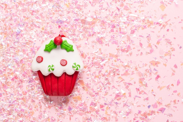 Vintage Plasticine clay cupcake on pink glitter . Minimal Christmas . Happy New Year. Flat lay, top view, copyspace