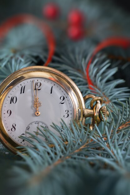 Vintage pocket watch showing five to twelve on gray rustic surface with Christmas