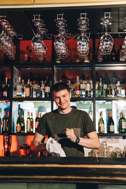 Ritratto d'epoca del barista che crea cocktail al bar primo piano della preparazione di bevande alcoliche