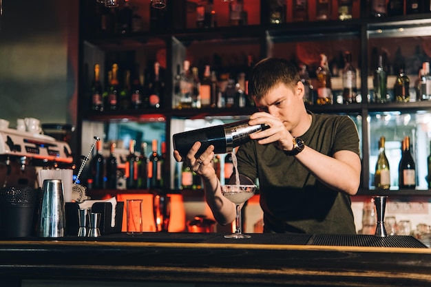 Vintage portrait of bartender creating cocktails at bar Close up of alcoholic beverage preparation