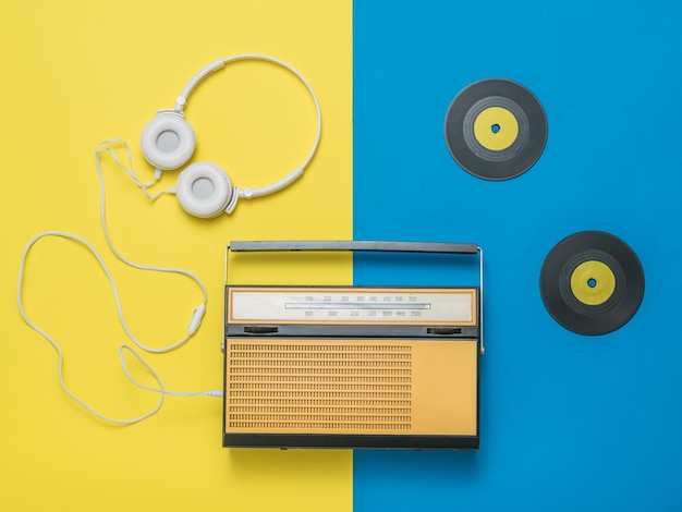 Vintage radio vinyl discs and headphones on a background of two
colors vintage technique