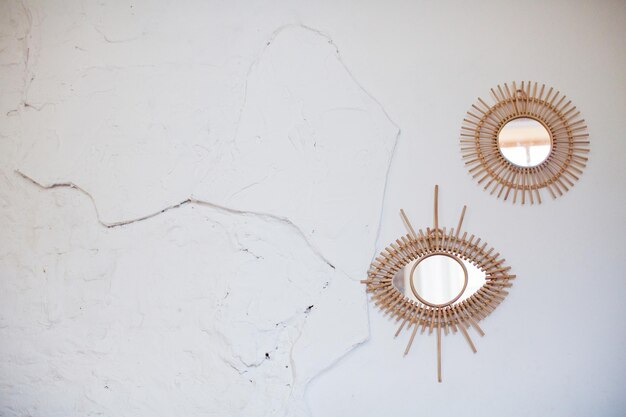 Vintage rattan mirrors on white textured wall Eye mirror and round mirror with frame of eco straws