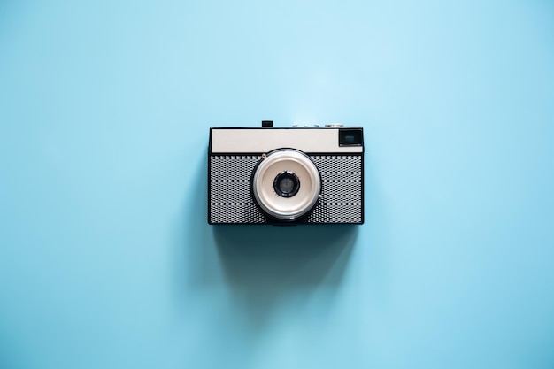 Vintage retro camera on a blue background flat lay