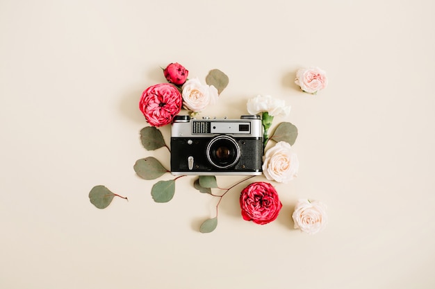 Vintage retro camera, red and beige rose flower buds pattern on pale pastel beige