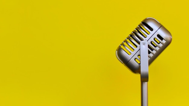 Винтажная и ретро-концепция Винтажный классический микрофон на желтом фоне Копирование места для текста