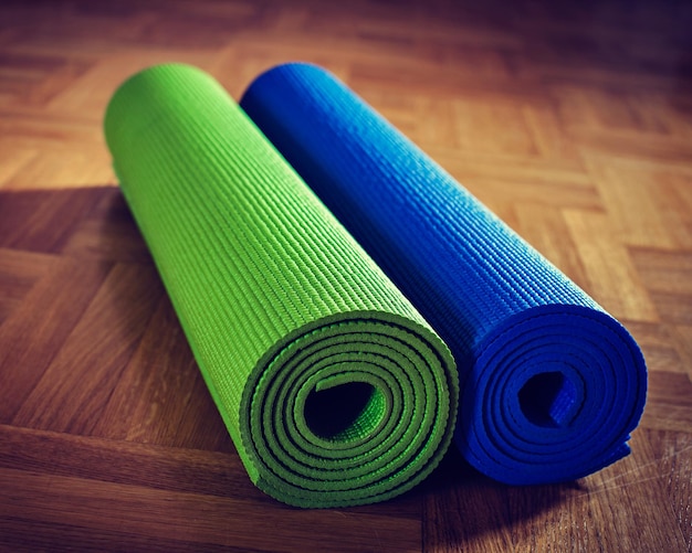 Vintage retro effect filtered hipster style image of Yoga mats on wooden floor