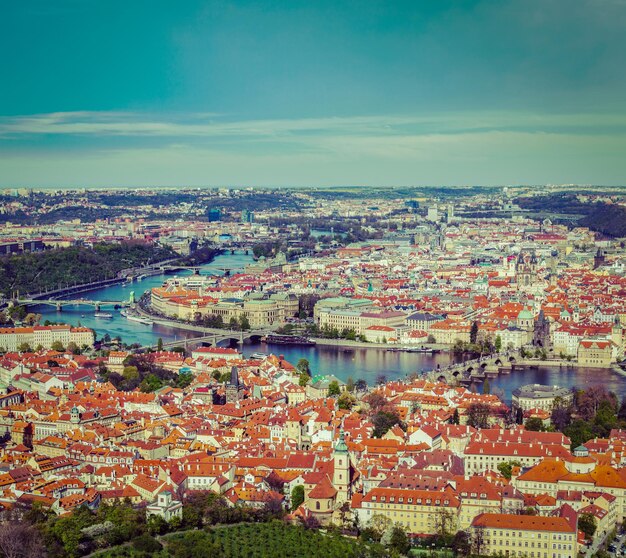 Vintage retro hipster style travel image of aerial view of charles bridge over vltava river and old city from petrin hill observation tower prague czech republic