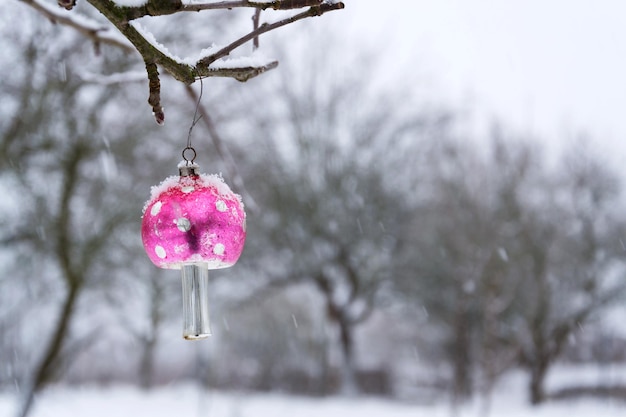 Vintage retro kerstboom glas decoratie besneeuwde rode paddestoel vliegenzwam buitenshuis winterlandschap sneeuw vallen op achtergrond