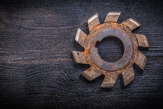 Vintage rotary cutter with cogs on wood board construction concept