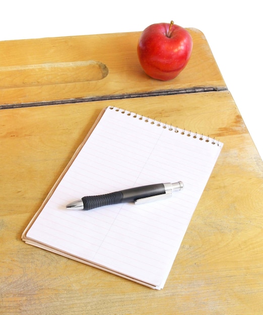 Vintage school desk with an apple and a note pad