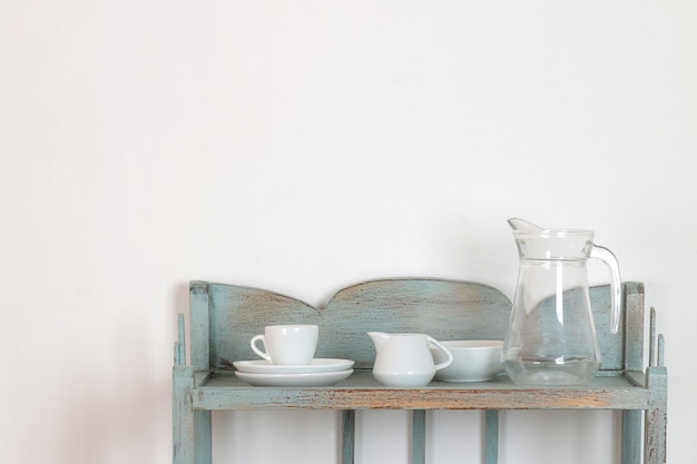 Photo vintage shelf with kitchenware on a white wall background. antique shelf. interior