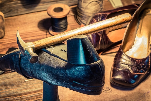 Photo vintage shoemaker workplace with tools shoes and leather