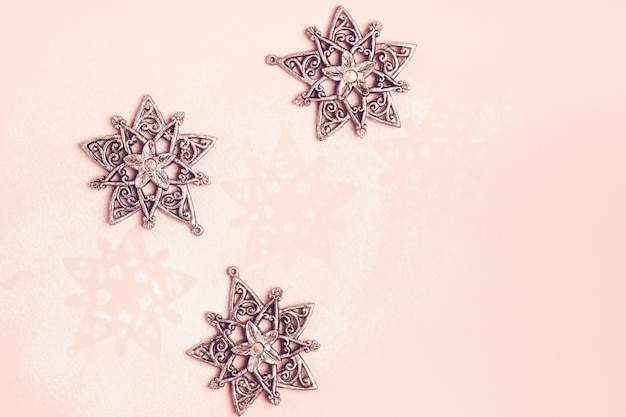 Винтажные серебряные рождественские игрушки снежинки на розовом фоне