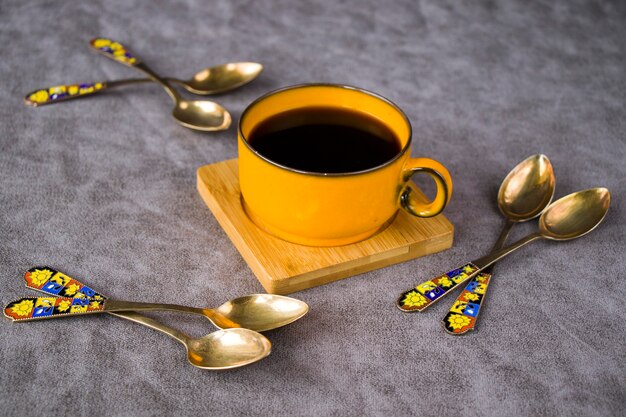 Vintage spoons, silverware, black coffee cup on the table