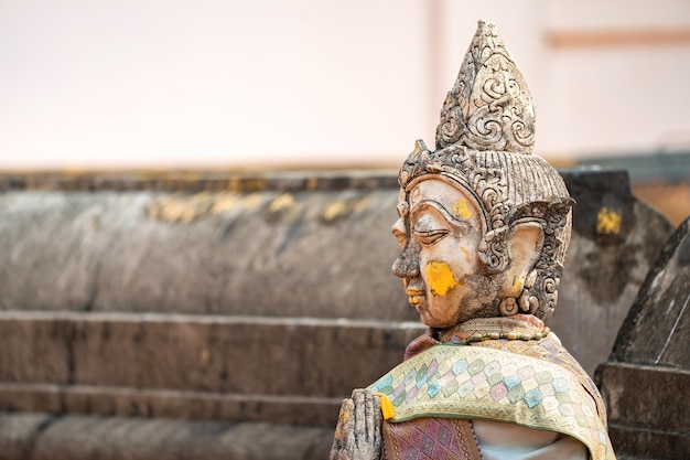 Foto vintage stenen traditioneel beeld in vrouwenkarakter aan de achterkant van wat phra that chom kitti, een aanbiddingsplaats in chiang rai, thailand