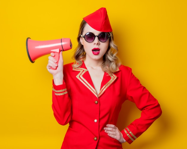 Vintage stewardess dragen in rode uniform met megafoon