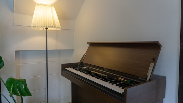 vintage stijl piano in de conner van kamer met lamp