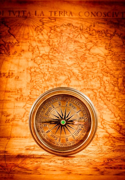 Vintage still life. vintage compass lies on an ancient world map in 1565