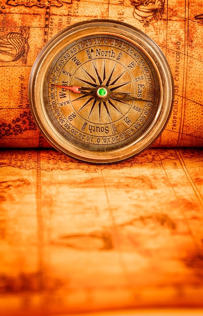 Старинный натюрморт. Винтажный компас лежит на древней карте мира 1565 года.