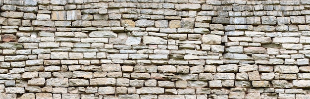 Foto muro di pietra vintage fatto di massi grigi sfondo di vecchia muratura