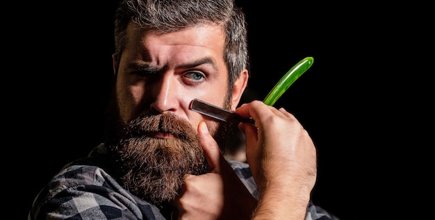 Vintage straight razor. Mens haircut. Man in barbershop.