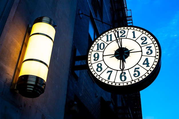 Vintage street clock sulla costruzione di new york city al tramonto