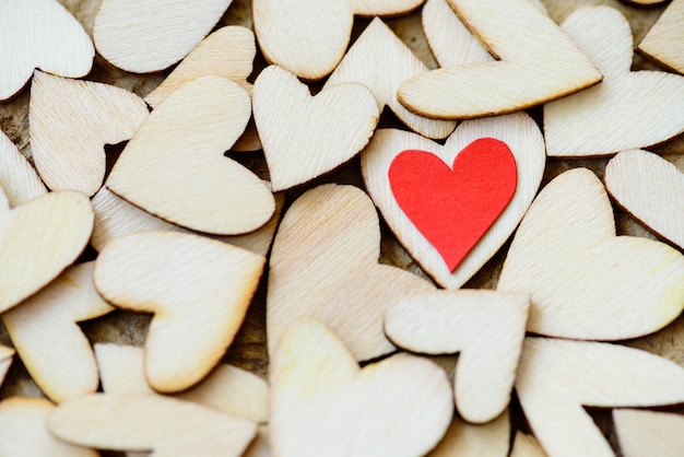 Vintage style of 2 red hearts with wooden hearts on a wooden background.