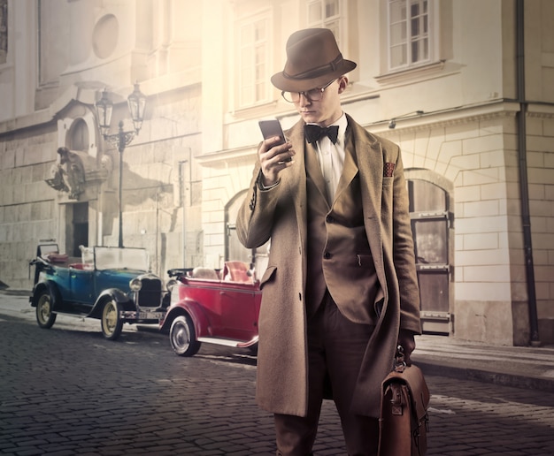 Uomo d'affari stile vintage con smartphone