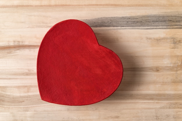 Vintage style red heart shaped box on the brown wood table. Directly above. Gift for Valentine's day