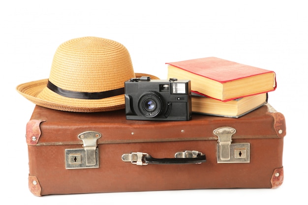 Foto valigia vintage e accessori isolati sul muro bianco