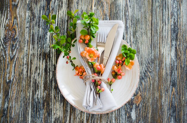 Vintage tabel instelling met delicate bloemen op rustieke shabby tafel.